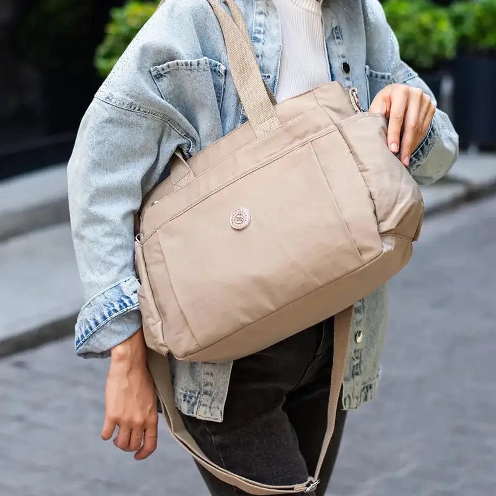 תיק צד COOLPASE דגם Carry Travel Tote בצבע חאקי נישא ברחוב בזמן נסיעה יומיומית, עיצוב אלגנטי ונוח