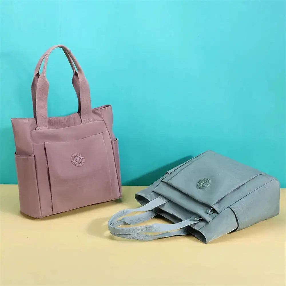 תיק צד COOLPASE דגם Carry Travel Tote בשני צבעים ורוד עתיק ואפור בהיר, זוג תיקים המדגים מגוון צבעים זמינים