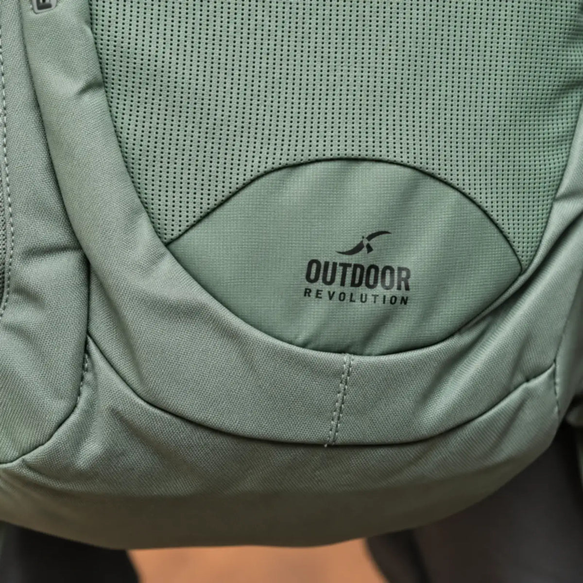 תקריב לוגו Outdoor Revolution על חזית תרמיל יום Fuji 24 בנפח 24 ליטר בצבע ירוק, בד עמיד במים בעיצוב ספורטיבי
