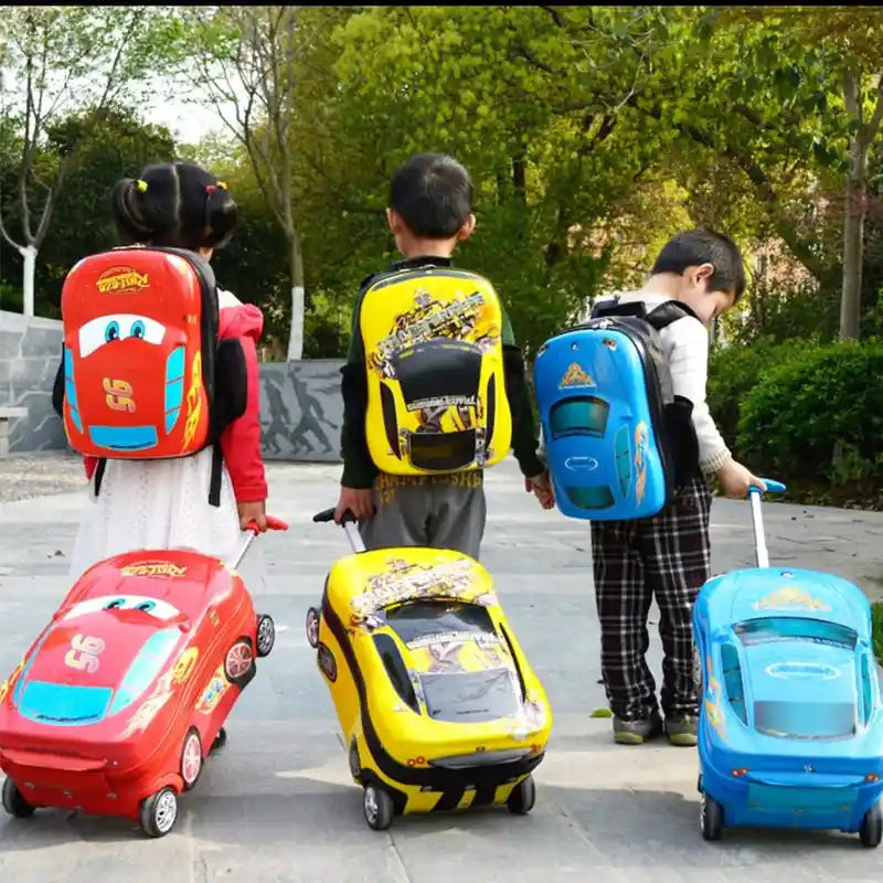 שלושה ילדים גוררים מזוודות ילדים קשיחות RollyBear בעיצוב מכונית ספורט, צהובה אדומה וכחולה, בחוץ