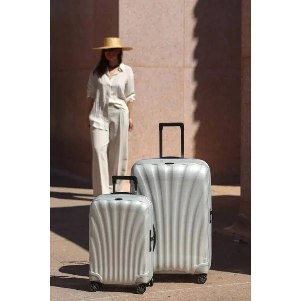 זוג מזוודות קשיחות Samsonite C-lite Spinner בצבע לבן פנינה, דגם גדול 28 אינץ' ודגם קבין, סצנת נסיעות