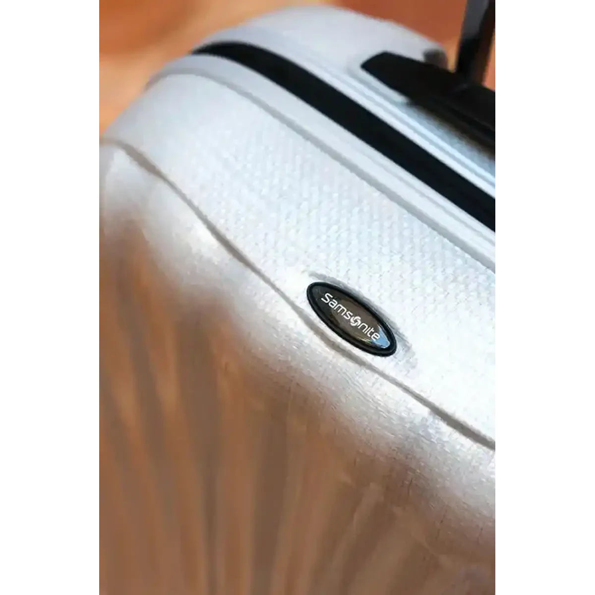 תקריב חומר CURV ולוגו Samsonite על מזוודת C-lite, פטנט ייחודי קל משקל ועמיד לשריטות לטיסה