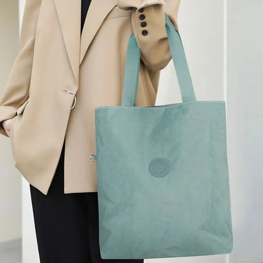 תיק צד יומיומי SEEINGLY Tote Bag בצבע מנטה בשימוש על הכתף עם מעיל חום, בד פרשוט קל משקל