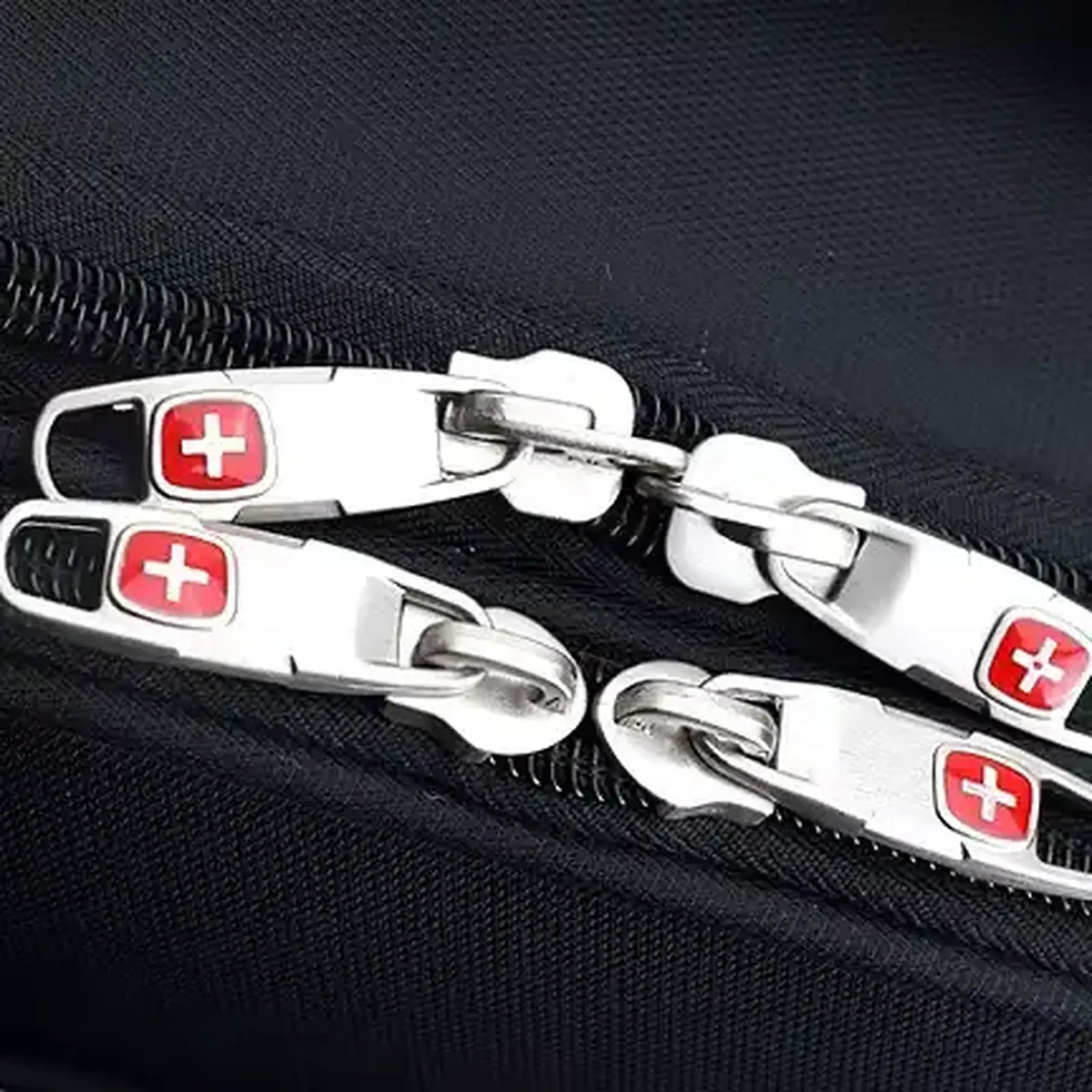 תקריב מושכי רוכסן ממתכת עם סמל הצלב של SWISS בתיק טרולי עסקי Executive 18 אינץ׳, רוכסנים כפולים איכותיים