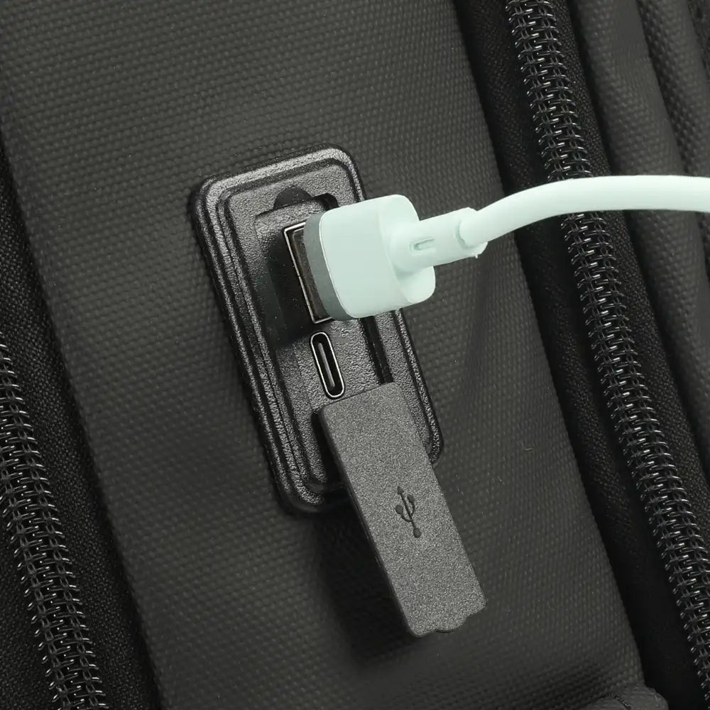 תיק גב Tigernu T-B9600 תקריב על שקע טעינה USB ו-Type C בצד התיק עם כיסוי סיליקון מוגן גשם