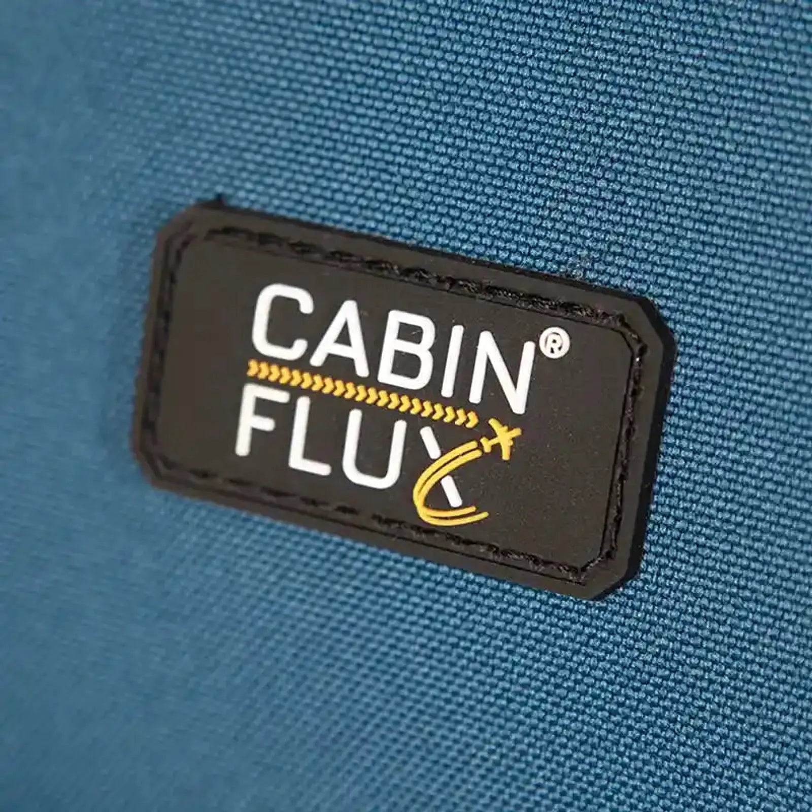 תווית מותג CABIN FLUX הקנדי על מזוודת Spirit C-Lite 33 אינץ' XXL, בד אולטרא לייט כחול עם שלדת קרבון, תקריב