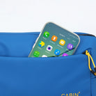 סמארטפון מבצבץ מהכיס הקדמי הנגיש של פאוץ' CABIN FLUX Apex Ranger בצבע כחול לשליפה מהירה