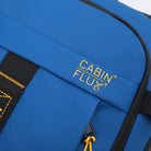 תקריב לוגו זהוב CABIN FLUX רקום על בד Ballistic Nylon כחול של תיק עלייה למטוס דגם Apex Ranger