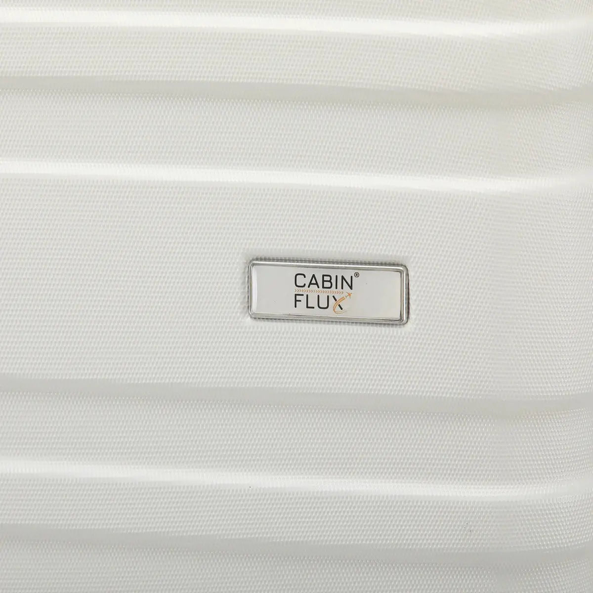 מזוודה בינונית CABIN FLUX Celine 24 אינץ' בצבע שמנת, תקריב על לוגו המותג וטקסטורת המעטפת הקשיחה
