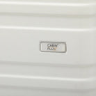 מזוודה בינונית CABIN FLUX Celine 24 אינץ' בצבע שמנת, תקריב על לוגו המותג וטקסטורת המעטפת הקשיחה