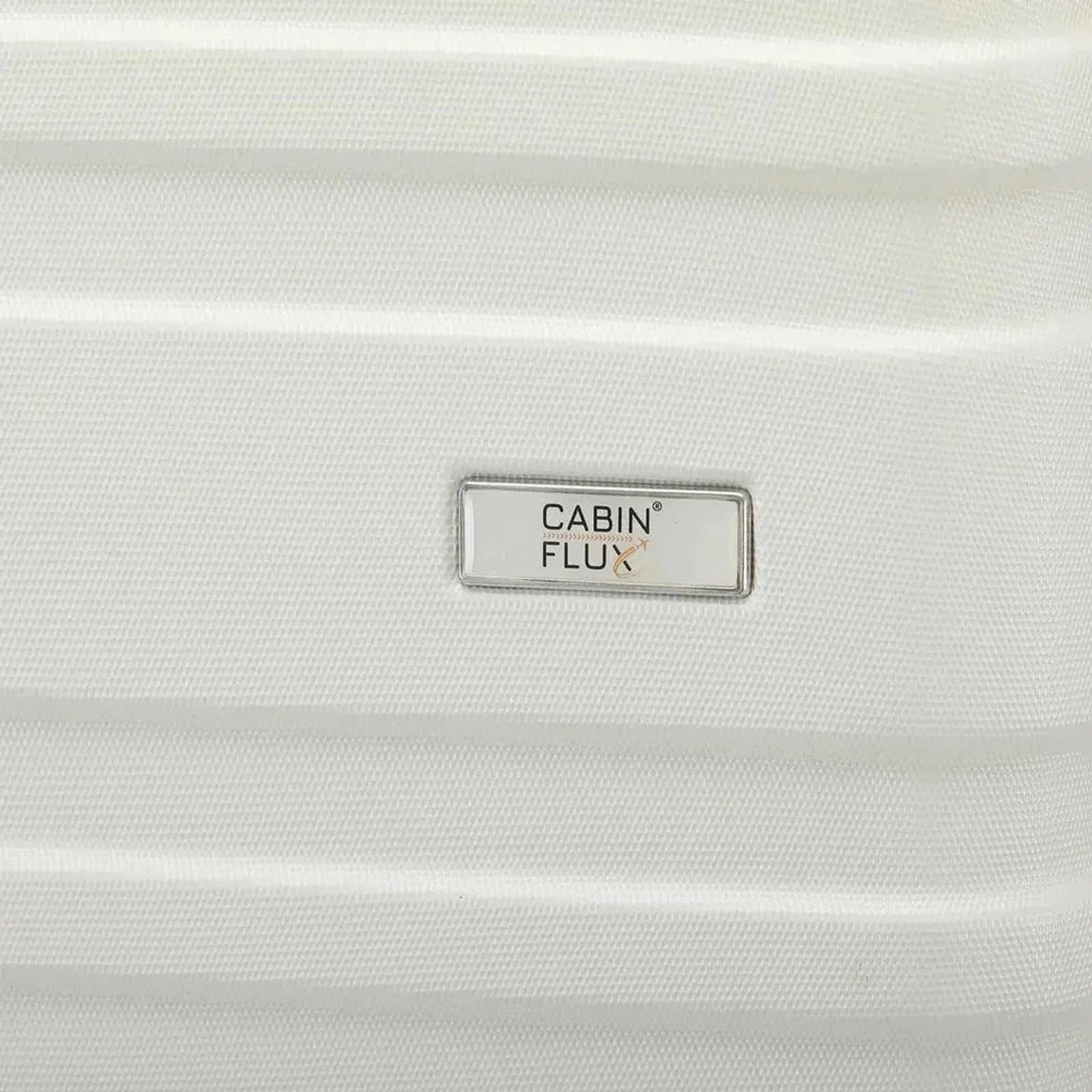 תקריב לוגו CABIN FLUX על מזוודה קשיחה Celine בצבע שמנת, חומר ABS, סימן מסחר רשום