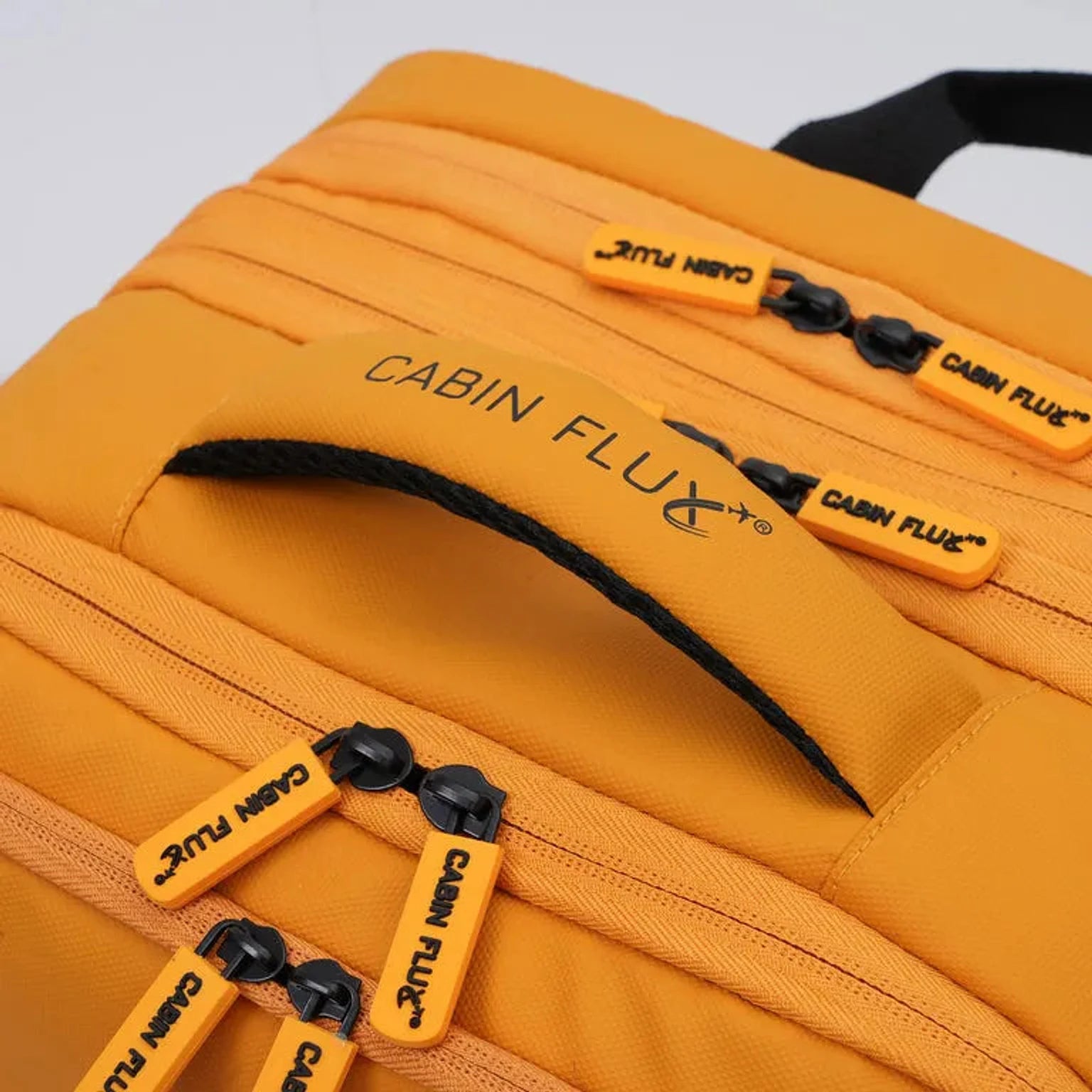 תיק עליה למטוס CABIN FLUX Iconic עם ידית עליונה מרופדת ותפירה מחוזקת, תקריב של הידית ואזור התליה