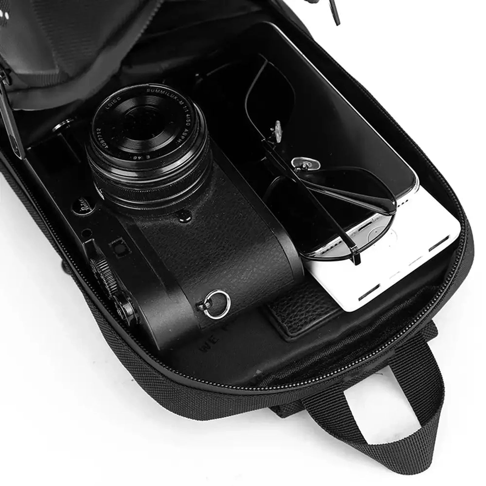 תיק קרוסבודי CABIN FLUX JetPack פתוח מציג תא ראשי מרווח עם מצלמה טלפון ומשקפיים, ארגון פנימי חכם