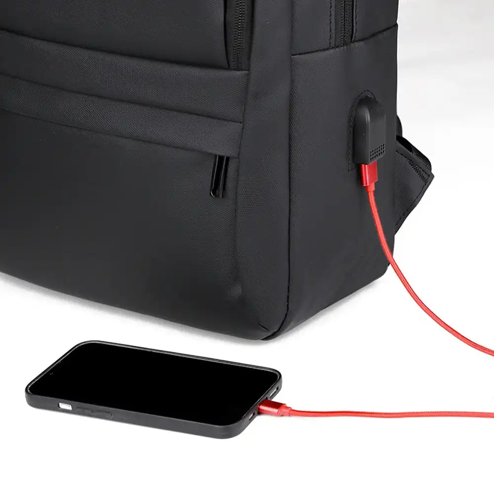 תיק גב CABIN FLUX Ranger בהדגמת שימוש בשקע USB לטעינת סמארטפון באמצעות כבל אדום מחוץ לתיק