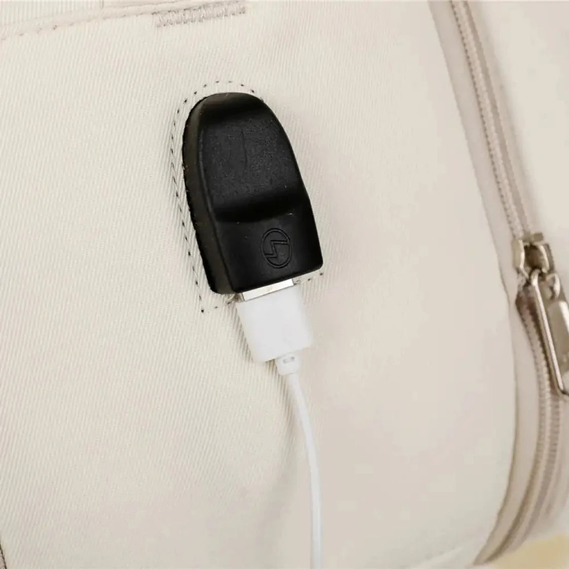 תקריב שקע USB חיצוני לטעינה של תיק עלייה למטוס נשי CABIN FLUX Vespra עם כבל טעינה מחובר