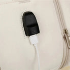 תקריב שקע USB חיצוני לטעינה של תיק עלייה למטוס נשי CABIN FLUX Vespra עם כבל טעינה מחובר