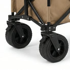 תקריב גלגלי שטח רחבים של עגלת GoNature Offroad Wagon II עם סטופרים לנעילה בגלגלים הקדמיים