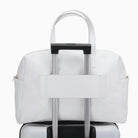 תיק נסיעות Kate Hill Bloom Overnight Tote מולבש על ידית טרולי מזוודה באמצעות שרוול אחורי, בצבע לבן