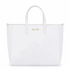 תיק נסיעות לבן Kate Hill Bloom Travel Tote עשוי מדמוי עור איכותי עם לוגו זהב מוטבע בחזית, מבט מלפנים