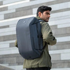 גבר נושא תיק גב Kingsons TRAVEL 40L עליה למטוס בנפח 40 ליטר בצבע אפור במהלך נסיעה עירונית