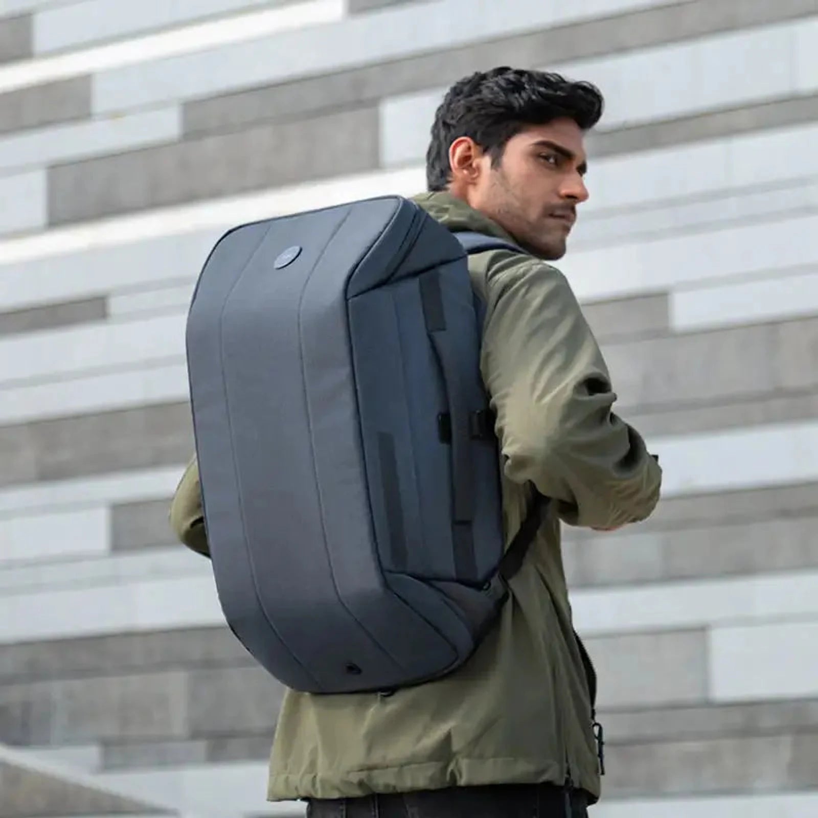 גבר נושא תיק גב Kingsons TRAVEL 40L עליה למטוס בנפח 40 ליטר בצבע אפור במהלך נסיעה עירונית