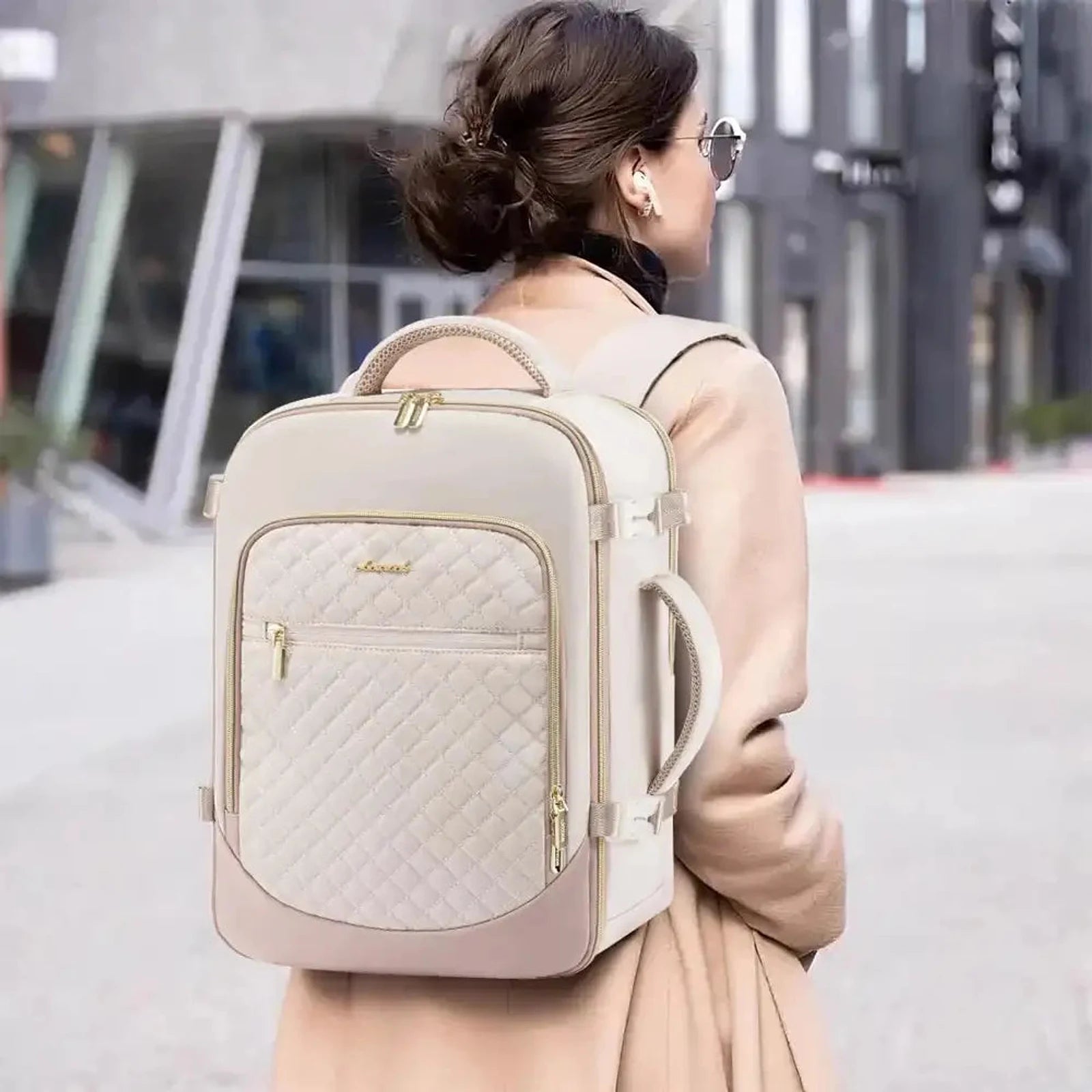 תיק גב נסיעות LOVEVOOK Urban Voyage 35L נשי בצבע אוף-ווייט נישא על גב של אישה, מבט אחורי בעיר