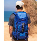 תרמיל טיולים Outdoor Revolution Cygni 45L בצבע כחול בשימוש בטיול חוף, עם כתפיות מרופדות ארגונומיות ומערכת גב אורטופדית