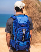 תרמיל טיולים Outdoor Revolution Cygni 45L בצבע כחול בשימוש בטיול חוף, עם כתפיות מרופדות ארגונומיות ומערכת גב אורטופדית