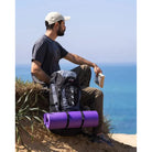 תיק טיולים Outdoor Revolution Cygni 45L בצבע כחול בסצנת שטח מול הים, עם רצועות חיצוניות לקשירת ציוד נוסף
