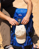 תיק טיולים Outdoor Revolution Cygni 45L בצבע כחול, תקריב תא עליון עם רוכסן בכובע התיק בשימוש בטיול שטח