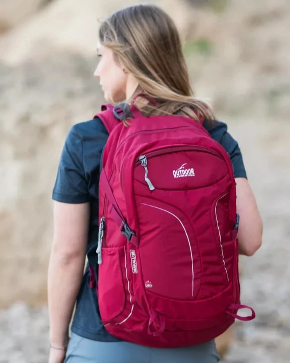 תרמיל גב Outdoor Revolution Makalu 28 ליטר אדום על גבה של מטיילת עם רצועות כתף מרופדות