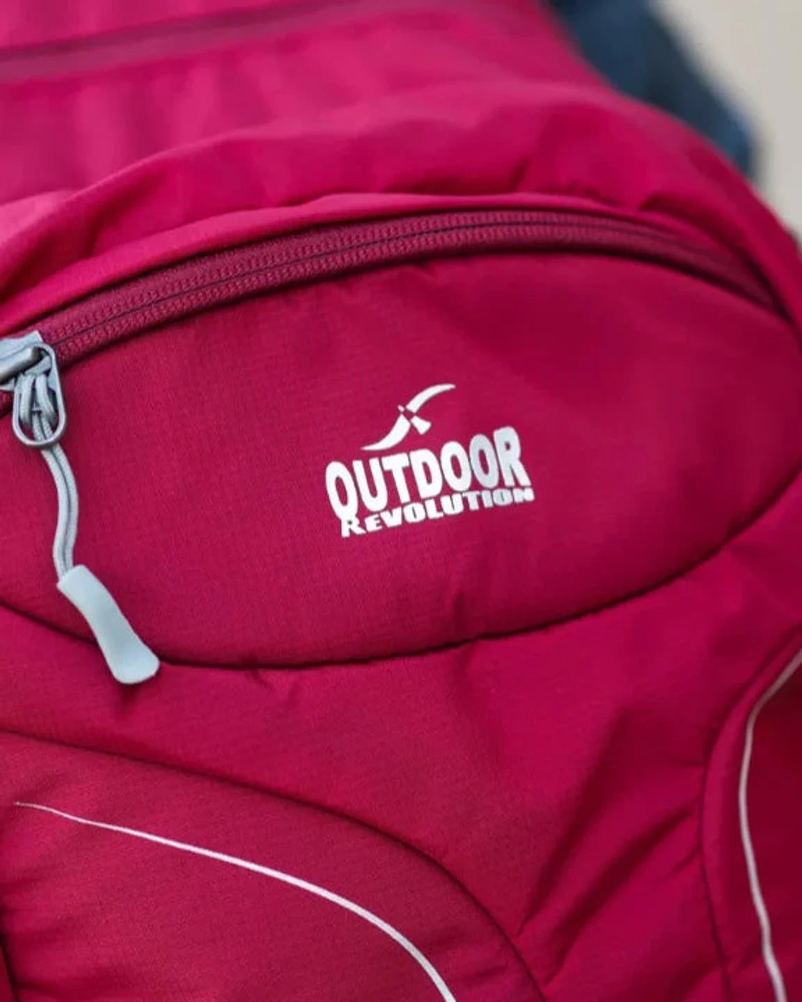 תקריב לוגו Outdoor Revolution על תרמיל Makalu 28 ליטר אדום עם בד פוליאסטר עמיד ורוכסן
