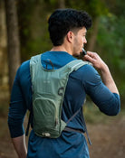 תיק גב שלוקר Outdoor Revolution Petrel בצבע ירוק בשימוש לשתייה במהלך טיול, צינור שתייה נוח וזמין בעת תנועה