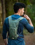 תיק גב שלוקר Outdoor Revolution Petrel בצבע ירוק בשימוש לשתייה במהלך טיול, צינור שתייה נוח וזמין בעת תנועה