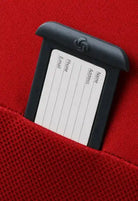 תקריב תג זיהוי אישי מובנה במזוודת Samsonite D'lite 78cm לרישום שם כתובת טלפון ואימייל על בד בליסטיק אדום