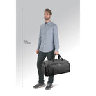 המחשת גודל: תיק דאפל SOLO New York דגם Highline 54 ליטר בצבע אפור נישא ביד לצד דוגמן בגובה 1.90 מטר