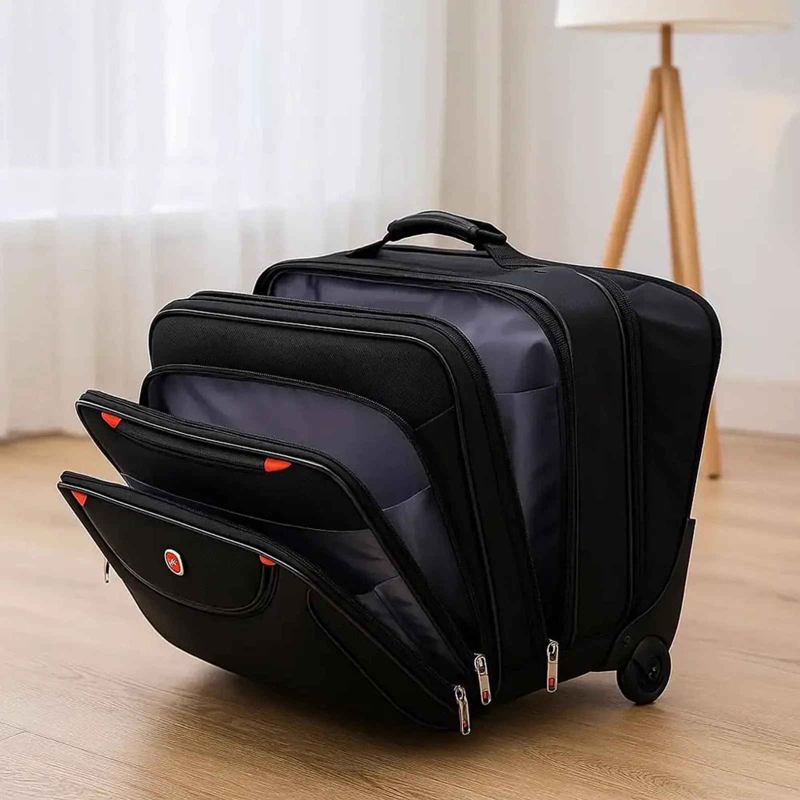 תיק טרולי עסקי Swiss Executive Glide 18 אינץ׳ עם שלושה תאים חזיתיים פתוחים ברקע סלון ביתי, פינות אדומות וגלגלי סיליקון