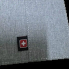 תקריב על לוגו SWISS האדום המובלט בכיסוי הדרכון Geneva, מעטפת EVA קשיחה בצבע אפור בהיר