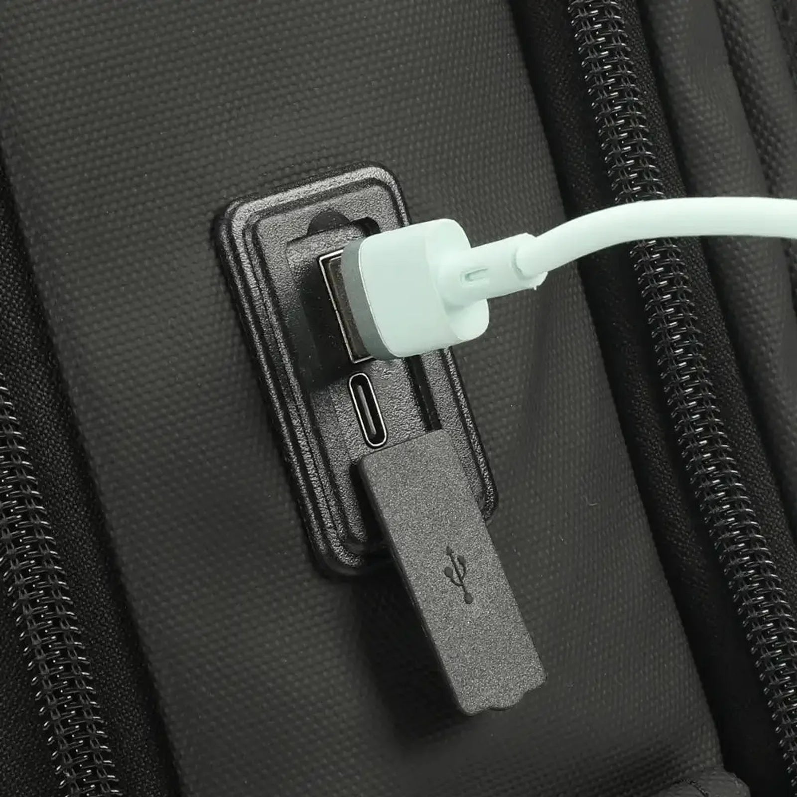תיק גב Tigernu T-B9600 תקריב על שקע טעינה USB ו-Type C בצד התיק עם כיסוי סיליקון מוגן גשם