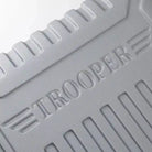 תקריב על לוגו TROOPER בחומר ABS מובלט על גוף המזוודה הקשיחה, מראה מרקם ייחודי ועיצוב קלאסי