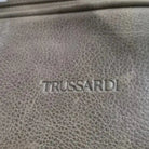 תקריב לוגו TRUSSARDI חרוט על עור ברידג' איטלקי איכותי, מראה מרקם העור האמיתי והתפר המוקפד של התיק