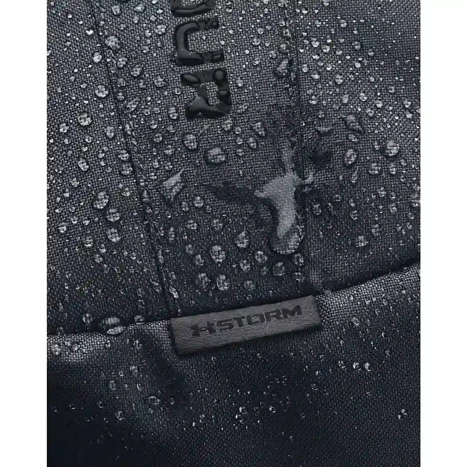 תקריב על בד דוחה מים UA Storm של תיק הגב Under Armour Hustle Lite אפור