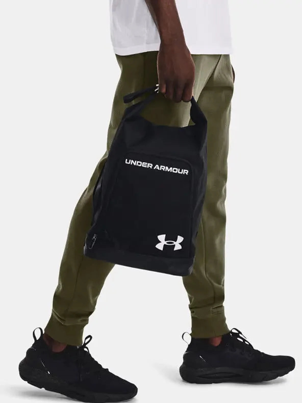 תיק נעליים ספורטיבי Under Armour Contain בצבע שחור נישא ביד על ידי גבר, תצוגת שימוש יומיומי
